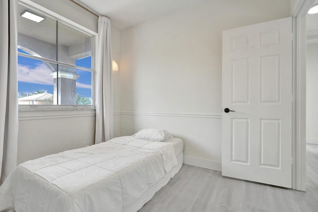 bedroom with baseboards and wood finished floors
