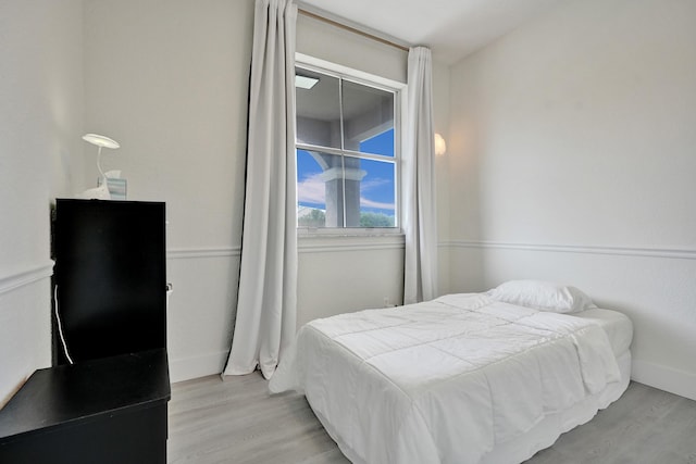 bedroom featuring wood finished floors and baseboards