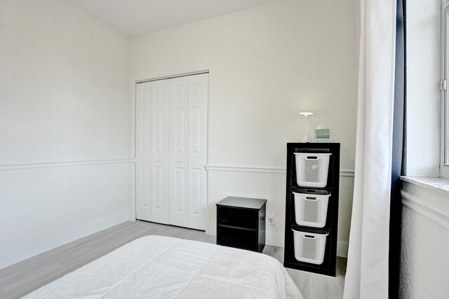 bedroom featuring a closet, baseboards, and wood finished floors