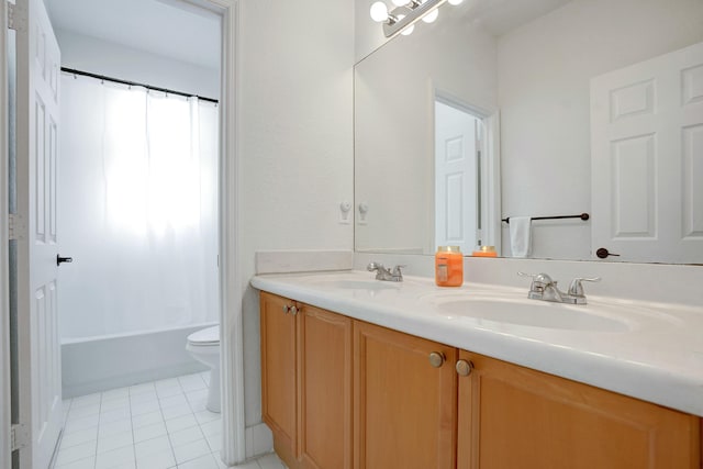 bathroom with a sink, tile patterned flooring, toilet, and double vanity