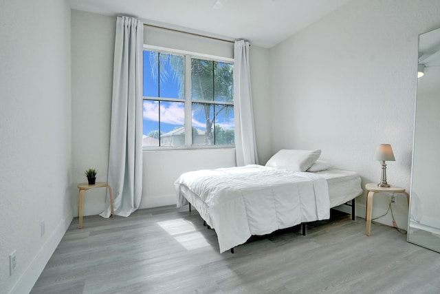 bedroom with baseboards and light wood-type flooring