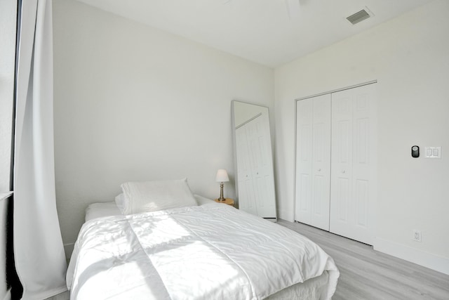 bedroom featuring baseboards, visible vents, and wood finished floors