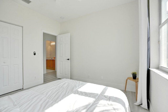 bedroom featuring baseboards, a closet, and wood finished floors