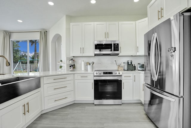 kitchen with white cabinetry, appliances with stainless steel finishes, a sink, and recessed lighting