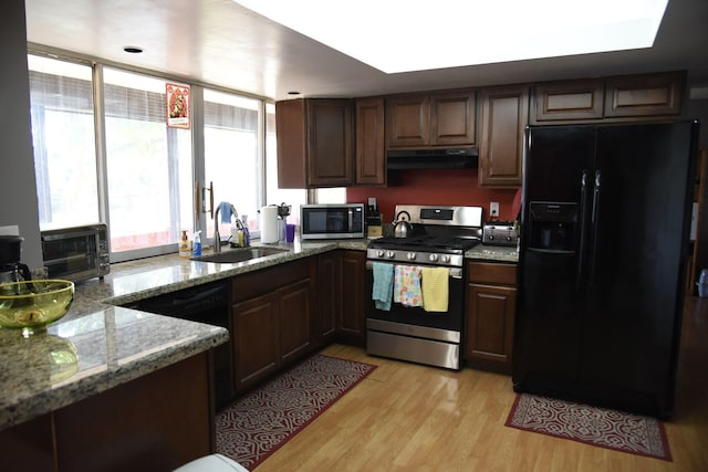 9170 NW 21st Mnr, Sunrise, FL 33322 - kitchen with stainless steel appliances, under cabinet range hood, light wood finished floors, light stone countertops, and dark brown cabinets