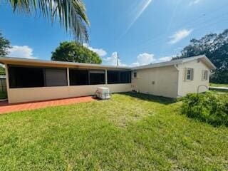 9170 NW 21st Mnr, Sunrise, FL 33322 - back of property featuring a sunroom, a lawn, and stucco siding