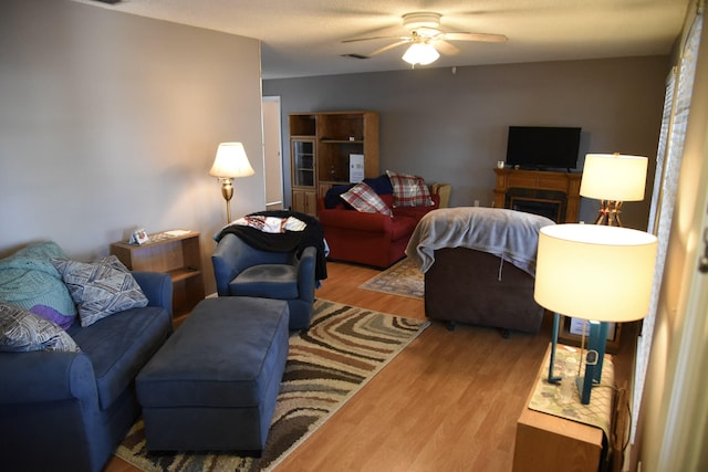 living room featuring visible vents, ceiling fan, and wood finished floors