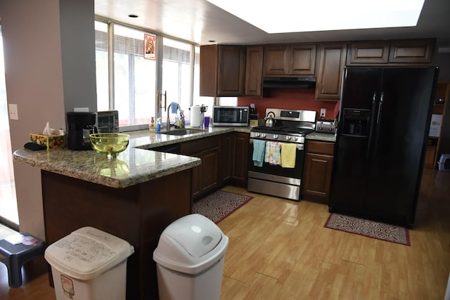 9170 NW 21st Mnr, Sunrise, FL 33322 - kitchen featuring stainless steel appliances, under cabinet range hood, a peninsula, light wood-style floors, and light stone counters