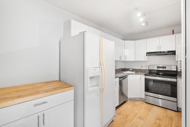 kitchen with a sink, stainless steel appliances, light wood-type flooring, under cabinet range hood, and white cabinets