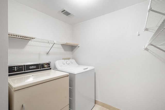 washroom with washing machine and dryer, laundry area, and visible vents