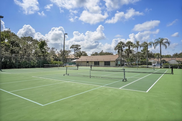 view of tennis court featuring fence and community basketball court