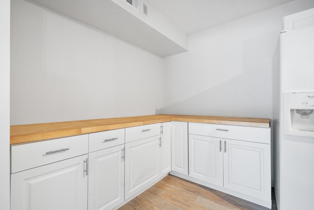 interior space featuring light wood-type flooring and a textured ceiling