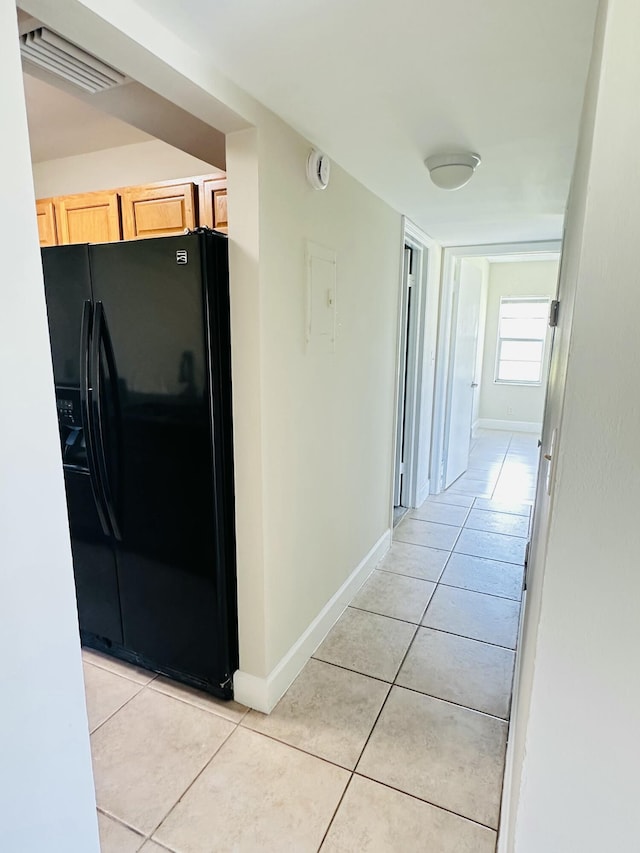 hallway with light tile patterned flooring, baseboards, and visible vents