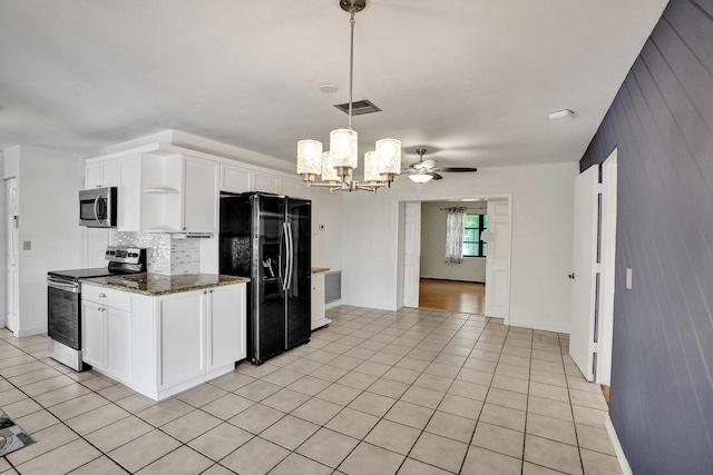 kitchen featuring stainless steel appliances, a chandelier, white cabinetry, backsplash, and wooden walls