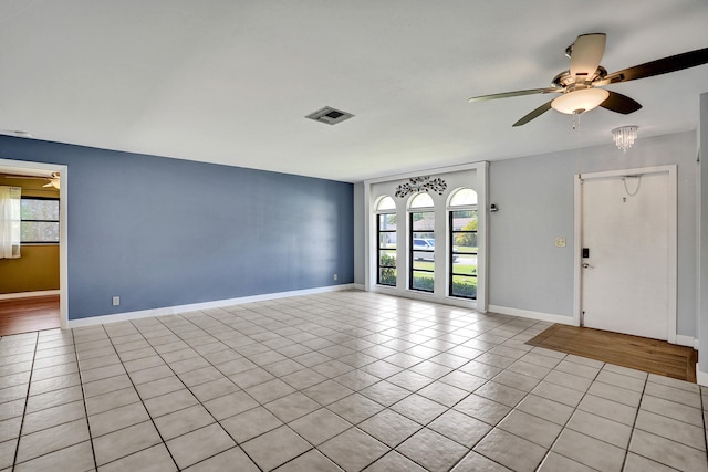 unfurnished living room with a ceiling fan, light tile patterned floors, and baseboards