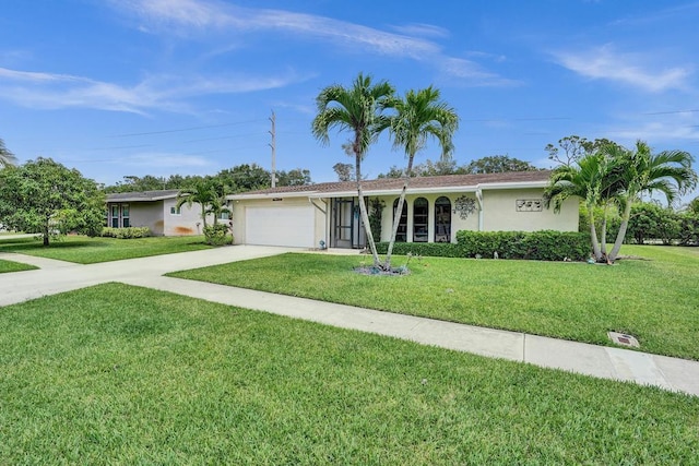 ranch-style home featuring driveway, an attached garage, a front yard, and stucco siding