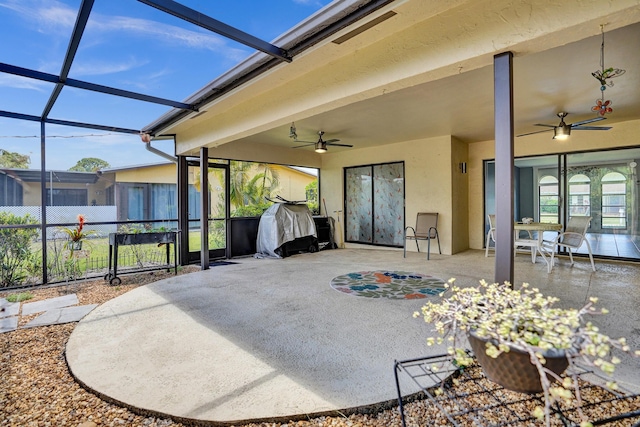 view of patio / terrace with a ceiling fan, fence, and glass enclosure