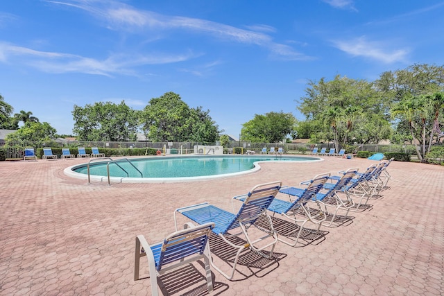 community pool with fence and a patio