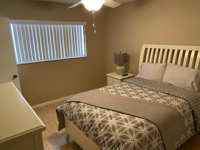 7076 Huntington Ln Unit 805, Delray Beach, FL 33446 - bedroom with light wood finished floors, baseboards, and a ceiling fan