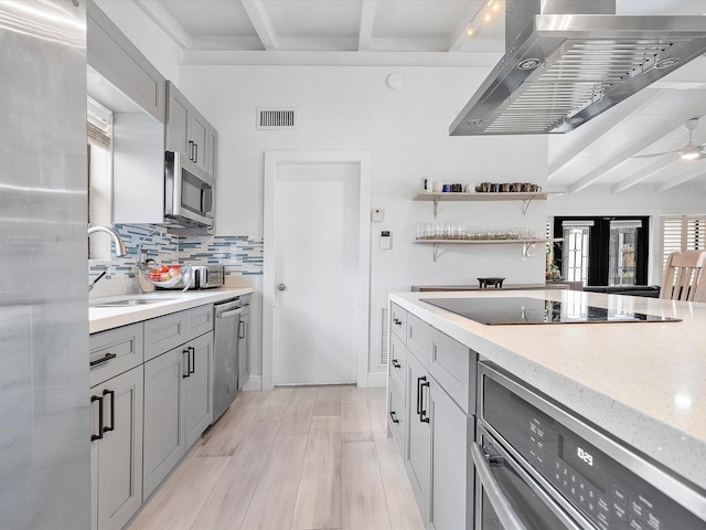 kitchen with gray cabinetry, visible vents, a sink, wall chimney exhaust hood, and appliances with stainless steel finishes