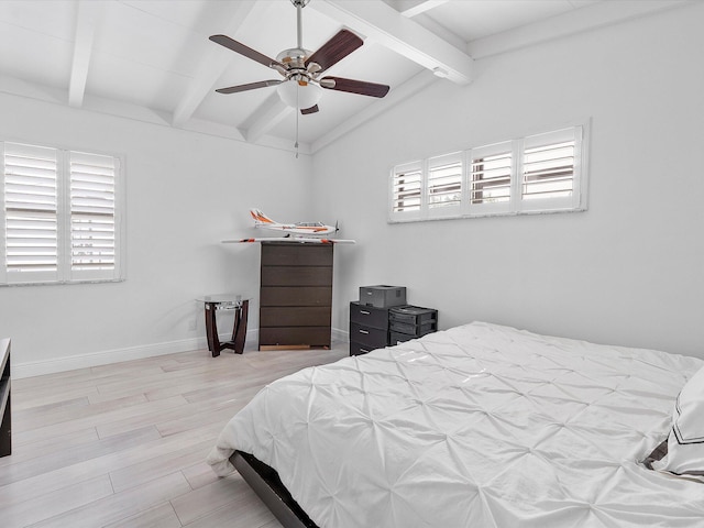bedroom featuring ceiling fan, wood finished floors, vaulted ceiling with beams, and multiple windows