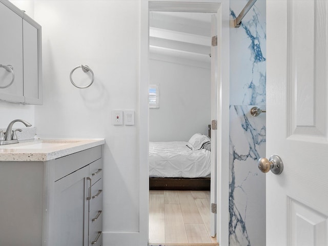 ensuite bathroom with vanity, ensuite bathroom, and wood finished floors