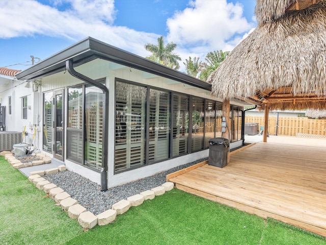 wooden deck featuring a sunroom, fence, and central AC