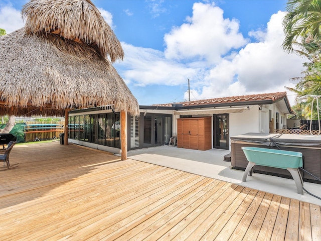 deck with a hot tub and a patio