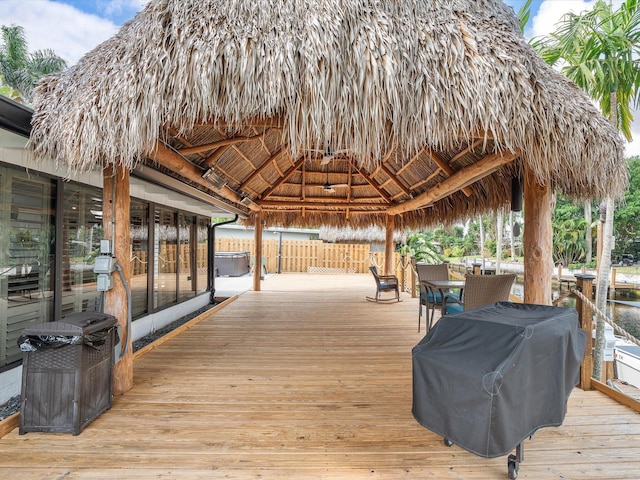 wooden terrace featuring a gazebo and fence
