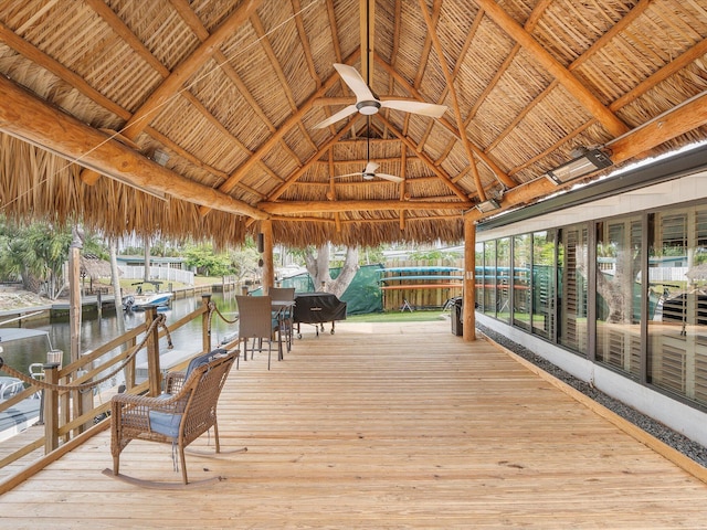 wooden deck with a gazebo, a water view, and a ceiling fan