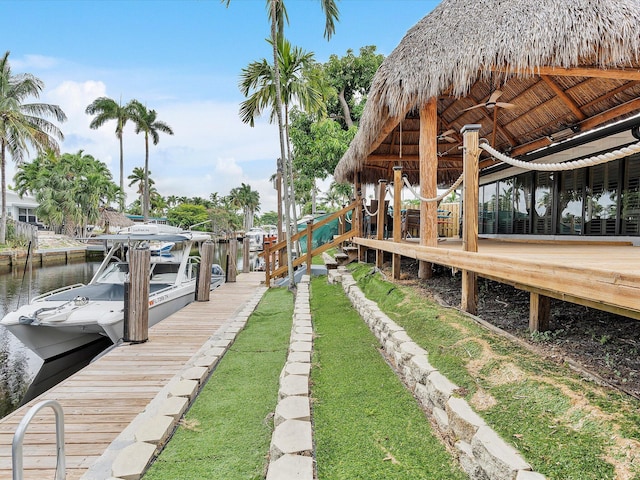 view of yard featuring boat lift, a water view, and a dock