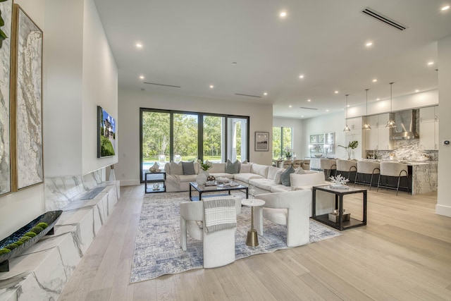 living area with recessed lighting, light wood-style floors, and visible vents
