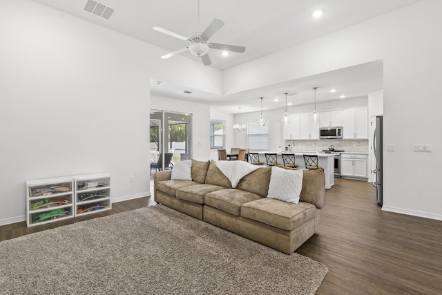 living area with recessed lighting, dark wood-style flooring, a ceiling fan, and baseboards