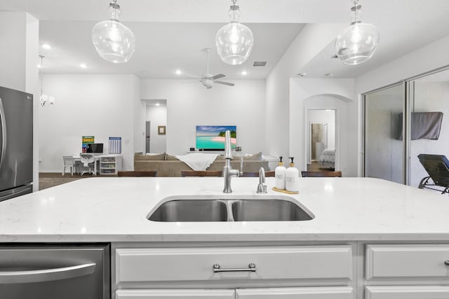 kitchen with open floor plan, a sink, white cabinets, stainless steel appliances, and recessed lighting