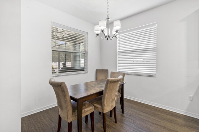 dining room with a chandelier, baseboards, and dark wood-style floors