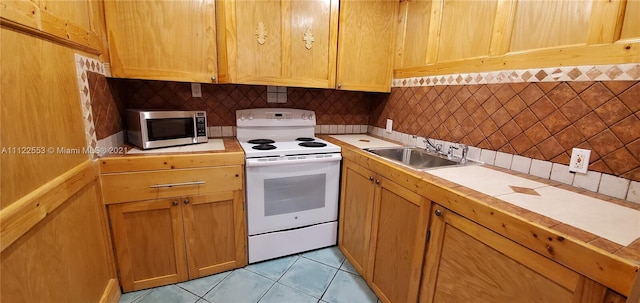 17 Brighton A 17, Boca Raton, FL 33434 - kitchen featuring electric range, stainless steel microwave, a sink, light countertops, and backsplash