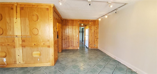 17 Brighton A 17, Boca Raton, FL 33434 - empty room featuring wooden walls, baseboards, track lighting, and a textured ceiling