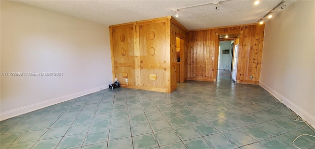 17 Brighton A 17, Boca Raton, FL 33434 - spare room with wood walls, rail lighting, and baseboards