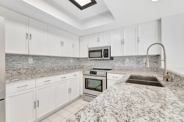 kitchen featuring stainless steel appliances, a sink, and white cabinets