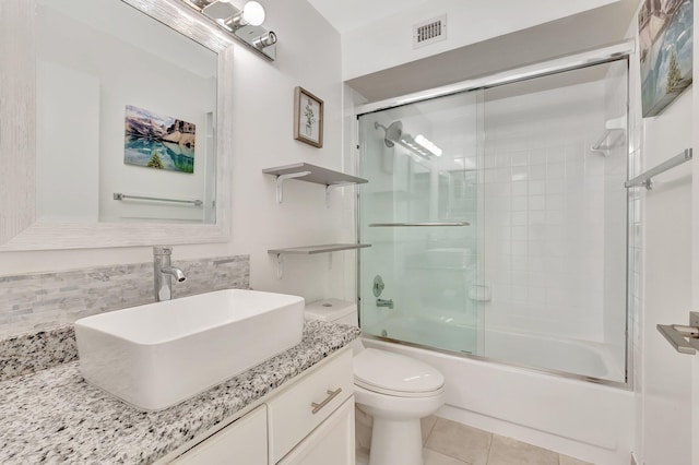 full bath with toilet, tile patterned floors, shower / bath combination with glass door, and vanity