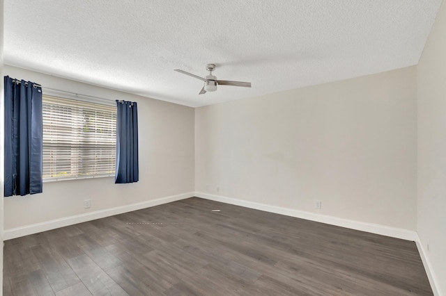 unfurnished room featuring dark wood-style flooring, ceiling fan, a textured ceiling, and baseboards