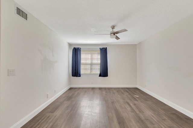 empty room featuring wood finished floors, a ceiling fan, baseboards, and a textured ceiling