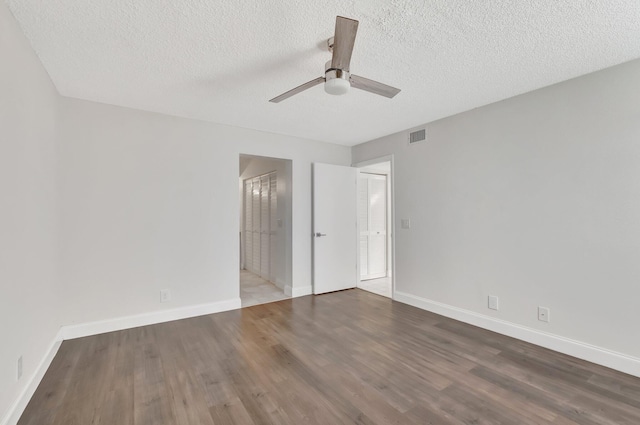 unfurnished bedroom featuring wood finished floors, baseboards, a textured ceiling, and a ceiling fan
