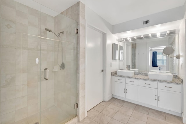 full bathroom featuring a shower stall, tile patterned floors, and double vanity