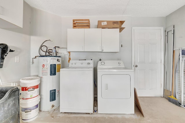 washroom featuring cabinet space, electric water heater, washing machine and dryer, and a textured ceiling
