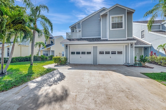 multi unit property featuring concrete driveway, an attached garage, a shingled roof, and a front lawn