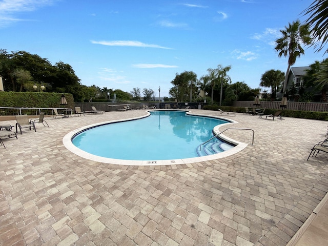 community pool featuring fence and a patio area