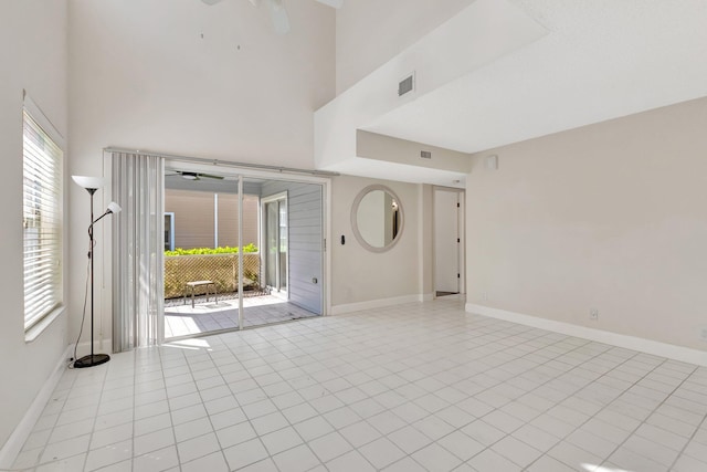 empty room with baseboards and a high ceiling
