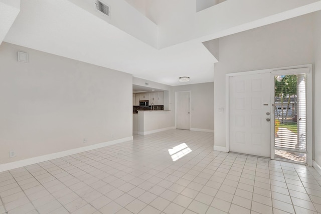 foyer featuring light tile patterned floors and baseboards