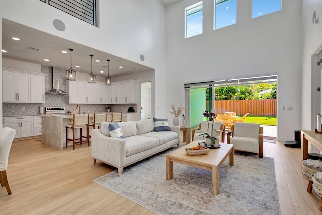 12952 Drayton Rd, North Palm Beach, FL 33408 - living room with light wood finished floors, visible vents, and a towering ceiling